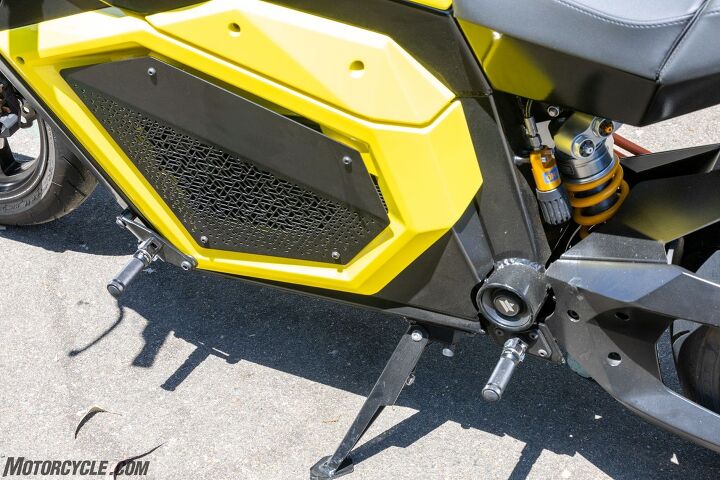 The battery itself is hidden away in its traditional spot behind covers. Both the battery and motor are air-cooled. A couple of things to note here: First is the Öhlins shock to compliment the Öhlins fork. Compression, rebound, and preload damping can be changed without tools. Second are the dual footpegs. If riding solo, they allow the rider to choose between mid-mount or forward foot placement. If there’s someone on the back, the mid pegs are theirs.