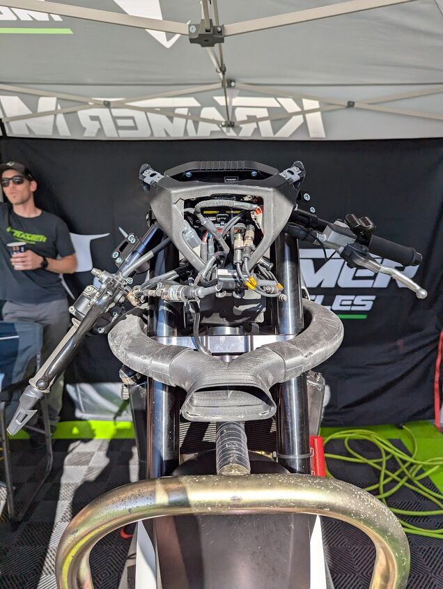 Without the bodywork, it’s clear to see the ram-air ducting. Behind that are the various cords and cables attached to various sensors that are feeding data back to the ECUMaster dash that simultaneously records data. Meanwhile, Krämer Joe looks on.